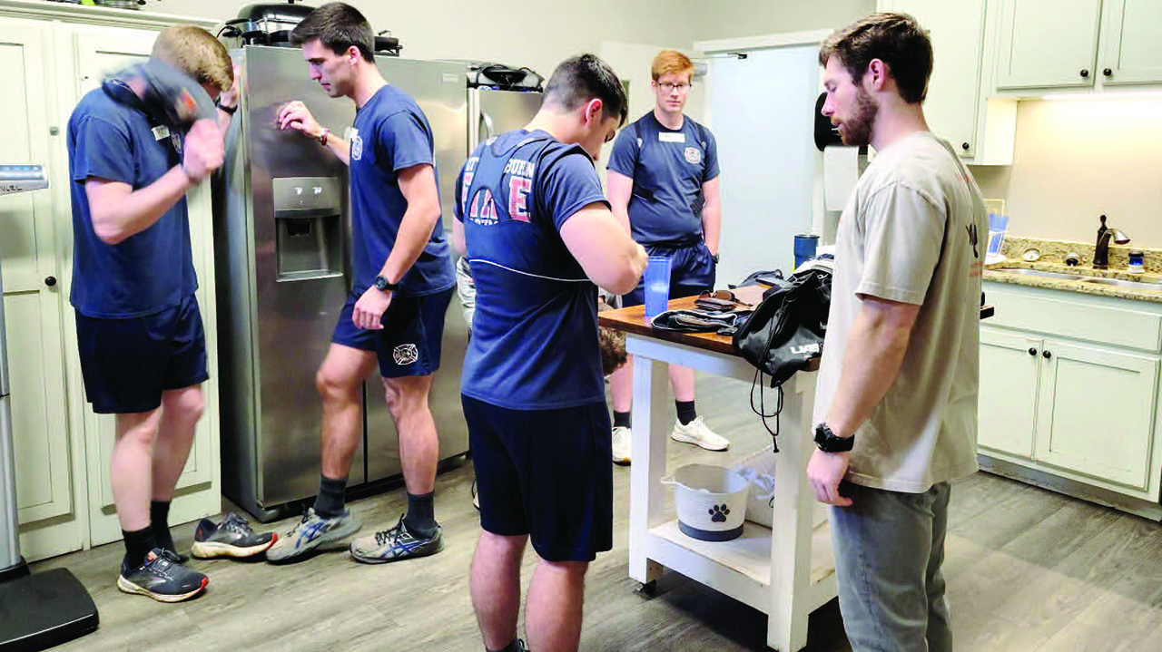 Members of the Warrior Research Center help Auburn firefighters put on equipment that will be used during data collection.