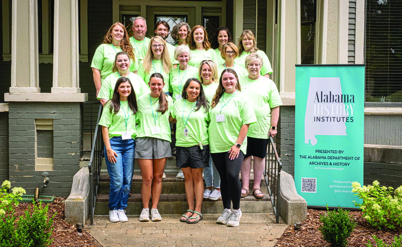 Group of people wearing light green shirts on stairs in front of a building