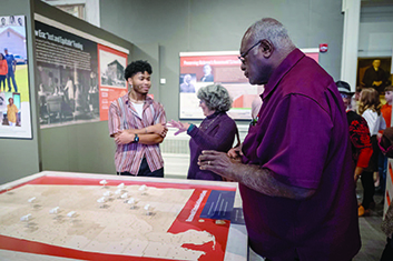 Man looking at a display of a map of Alabama