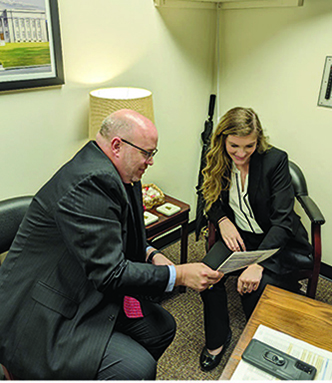 Katie Couture, Rep. Phillip Rigsby review document.