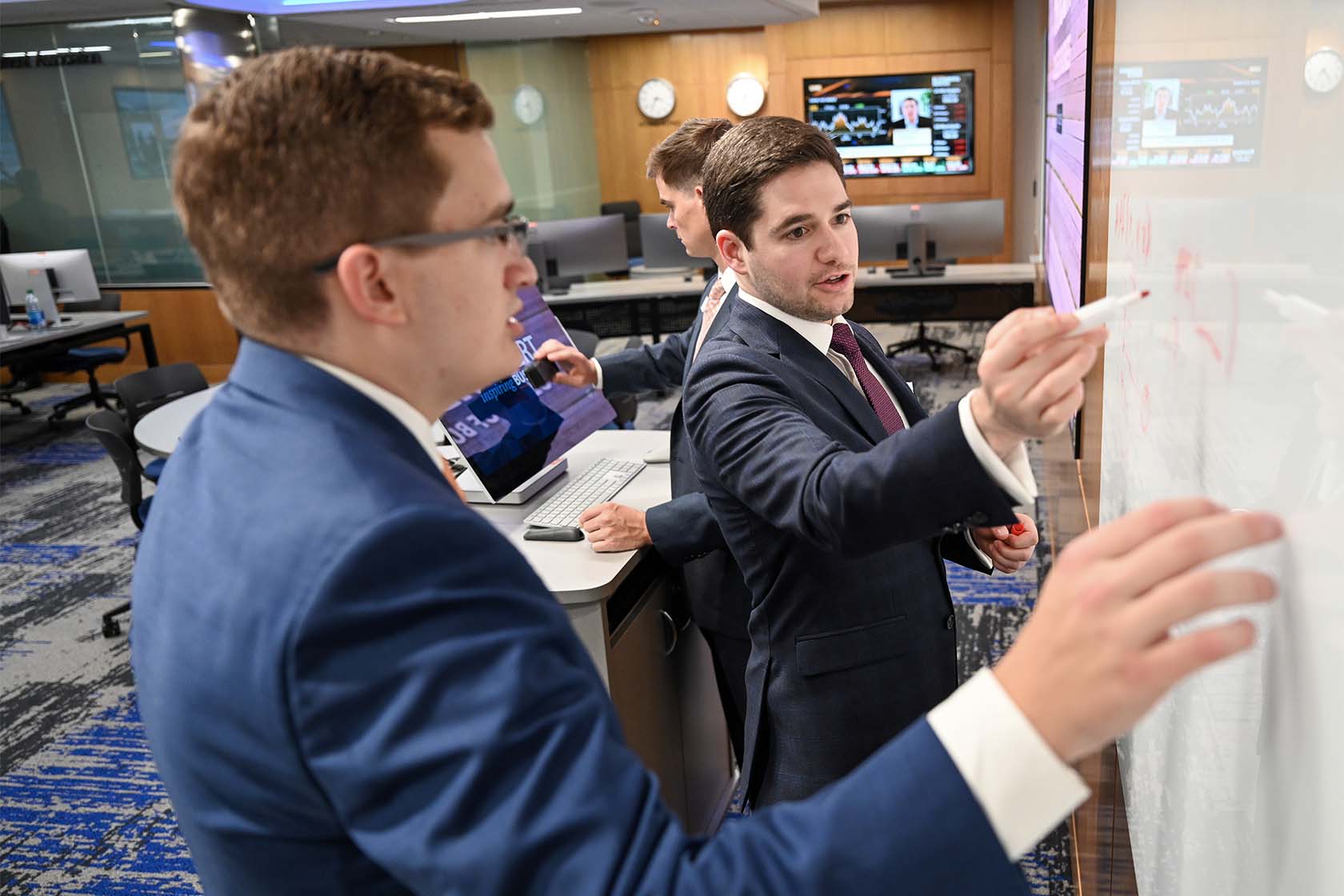 College of Business students writing on white board