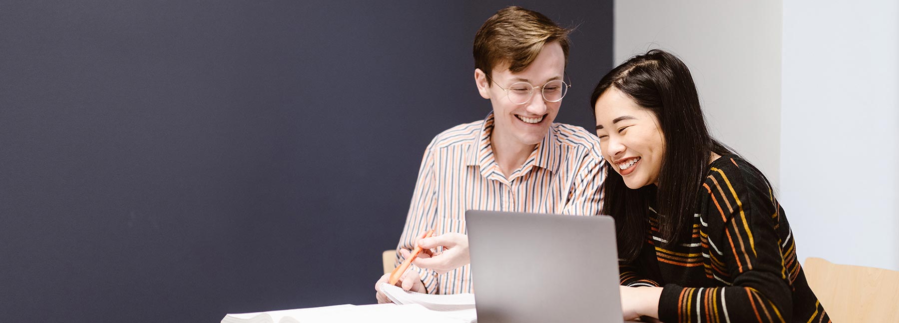 Two students look at a notebook together