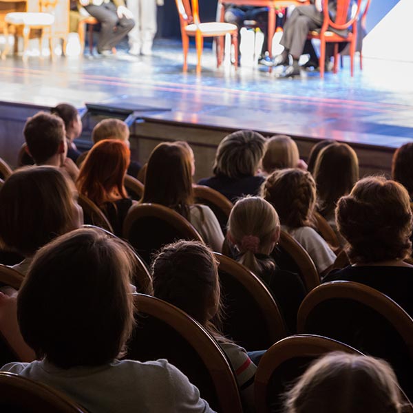 Audience members whatch a performance.