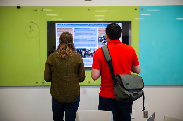 Two students look at a computer monitor