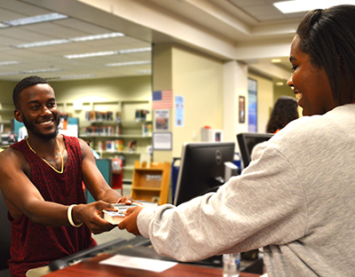 Student checking out a book at the library