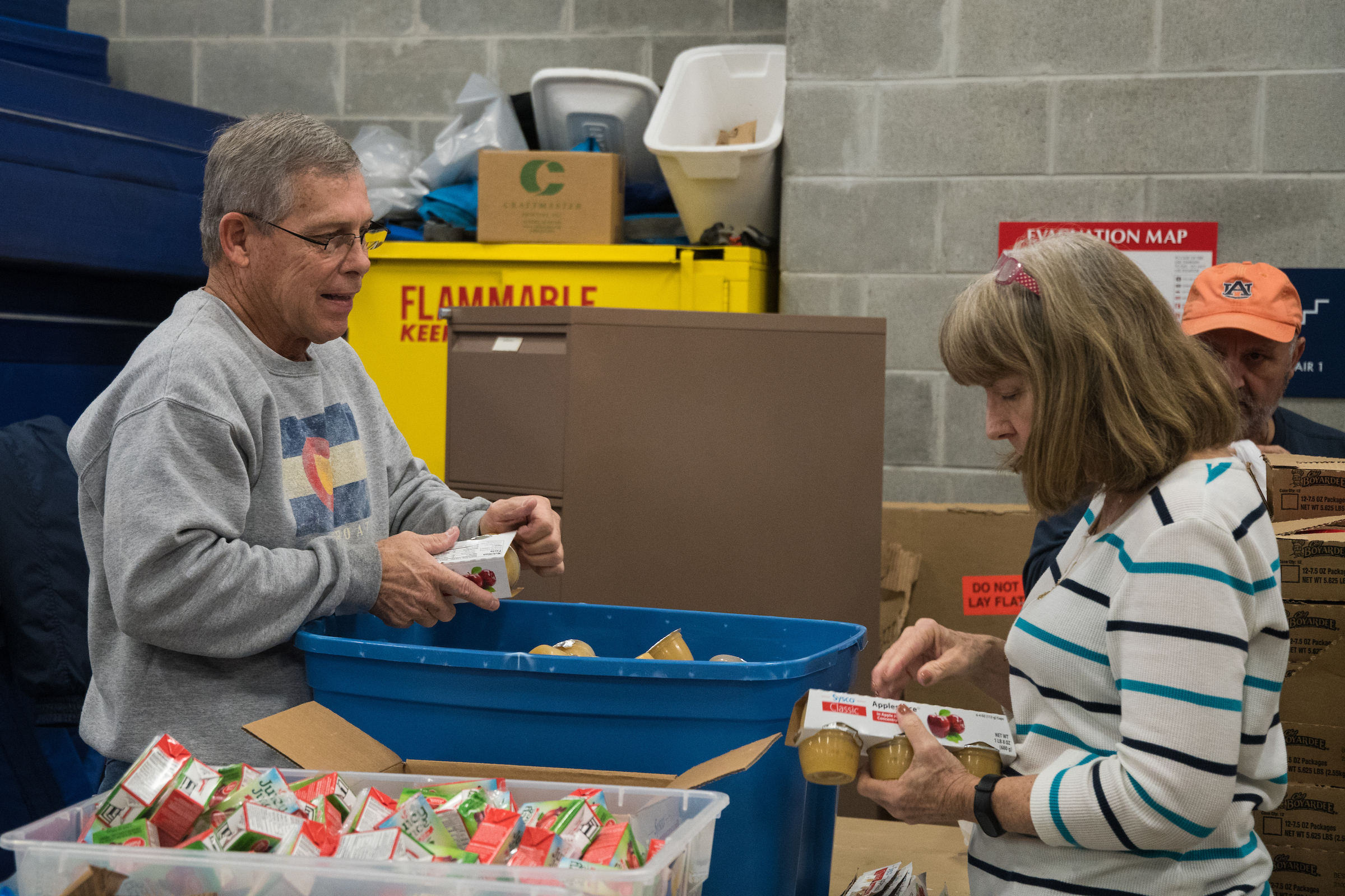 two volunteers boxing food