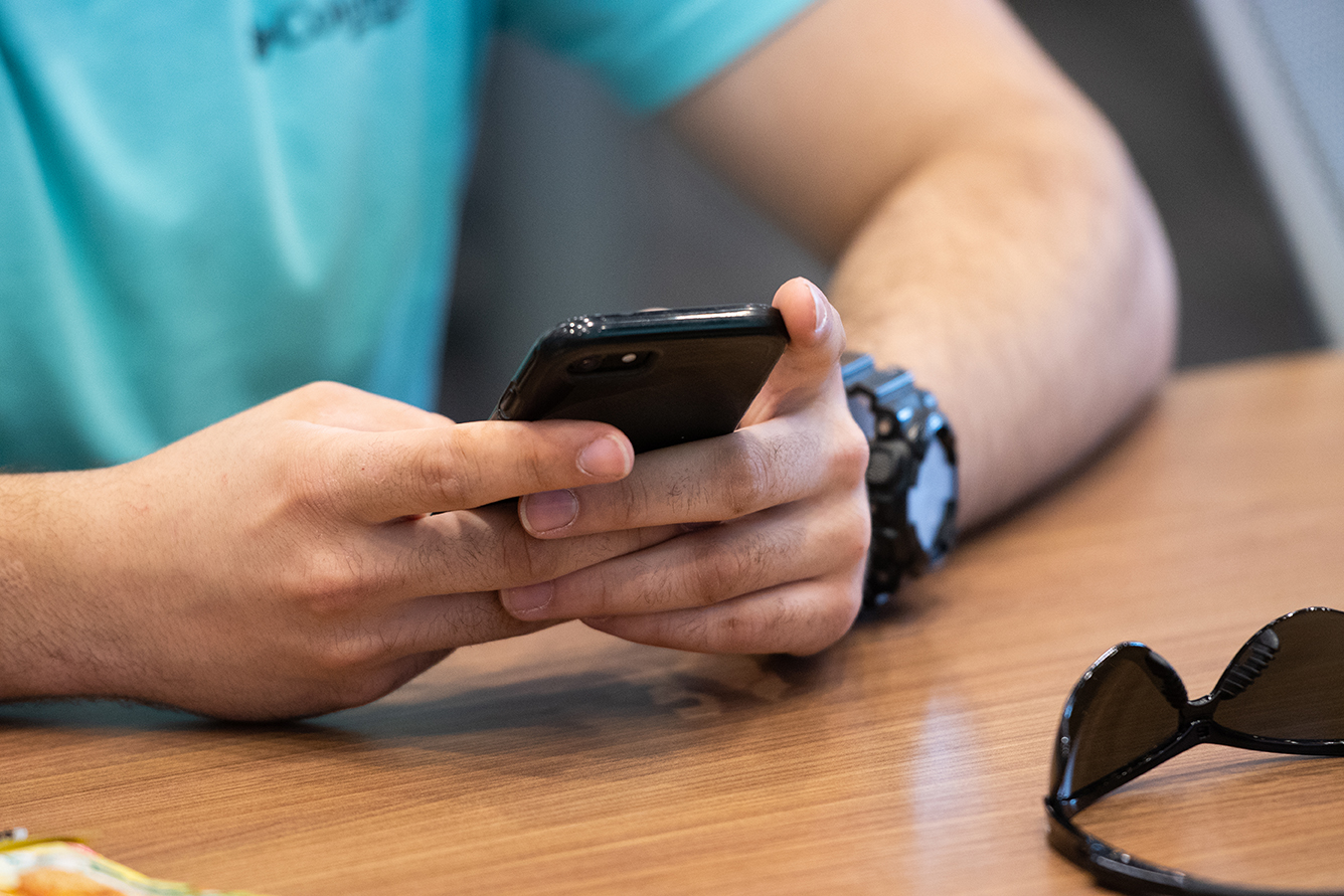 A places mobile device on contactless ID reader.