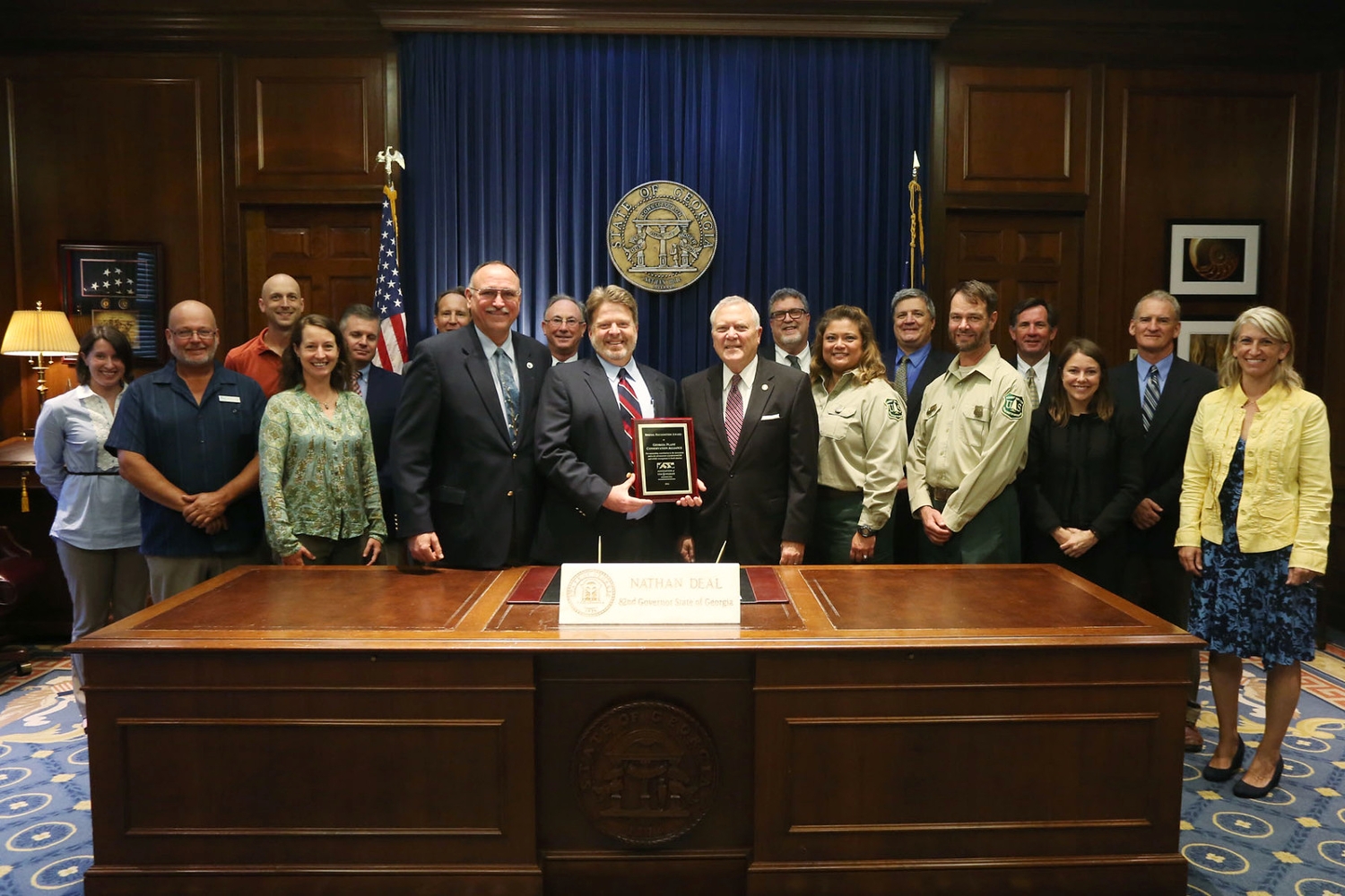 Mincy Moffett receiving a plaque from Georgia Governer Nathan Deal for the Association of Fish & Wildlife Agencies Award