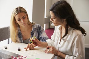 Woman helping another woman study.