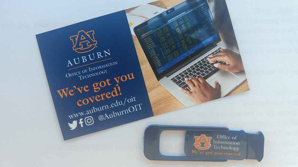 An Auburn OIT webcam cover and instructional card.
