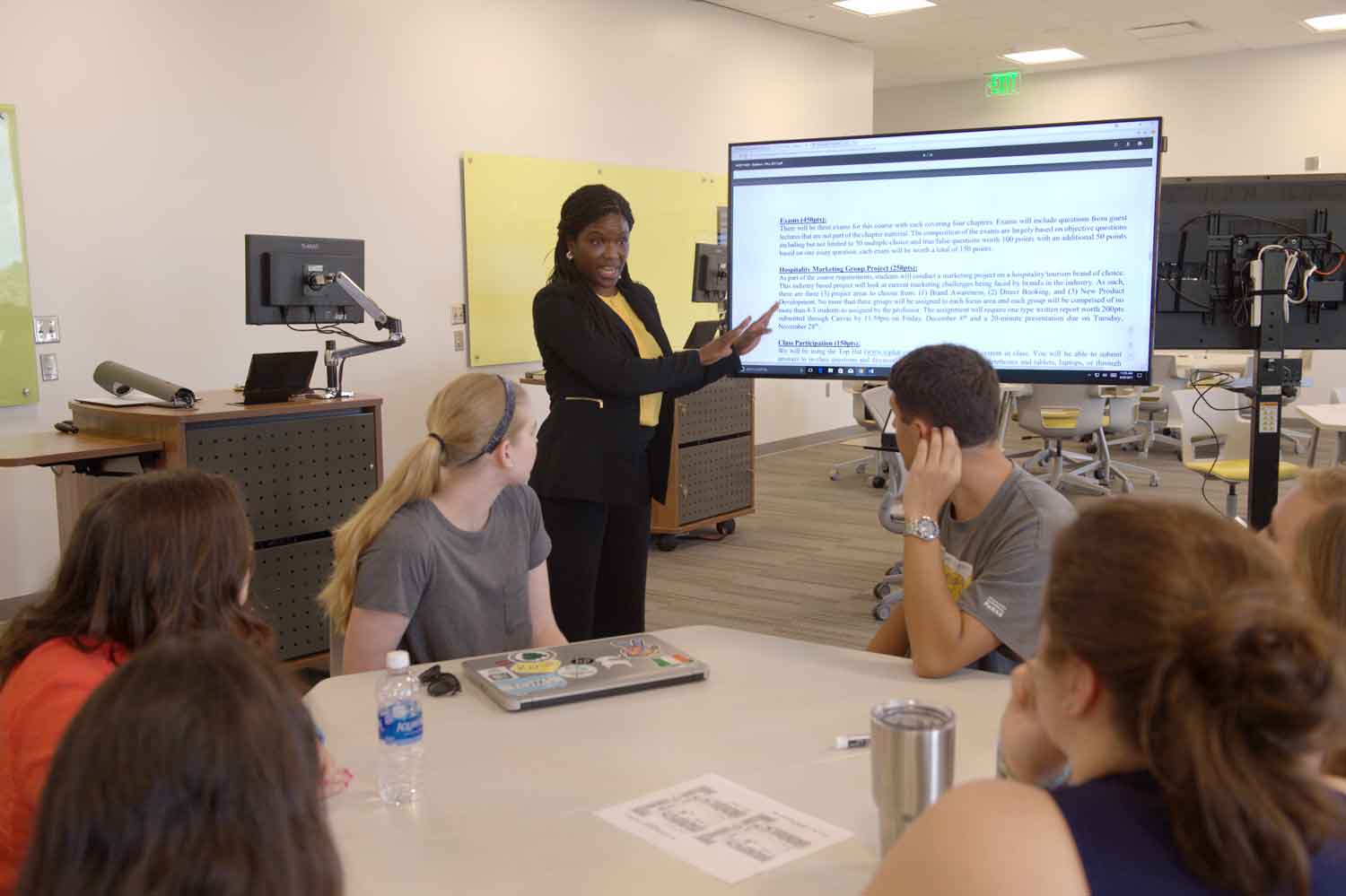 Teacher pointing at screen in Mell classroom.