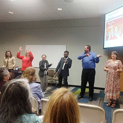 An OIT employee, with other admin professionals, forming a human machine at the Administrative Professionals Conference