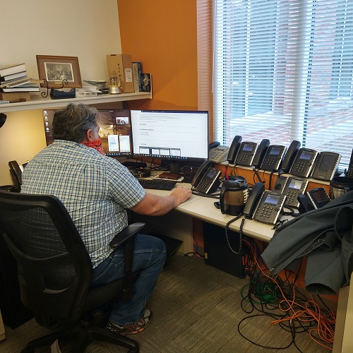 A member of the telecommunications team reviewing phone installation needs