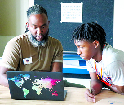 a mentor and student work on a laptop