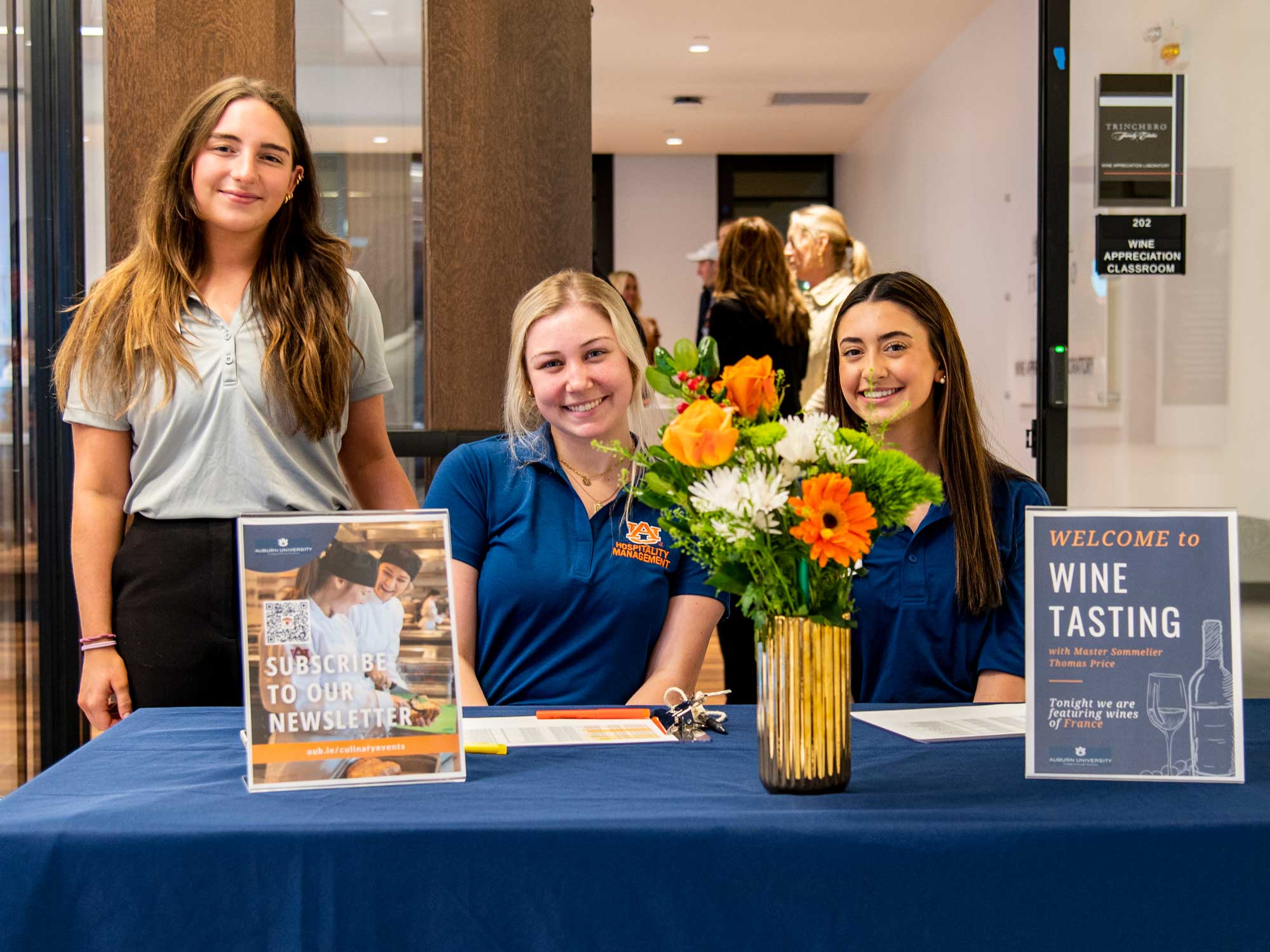 Photo of three students at the check for a wine tasting.