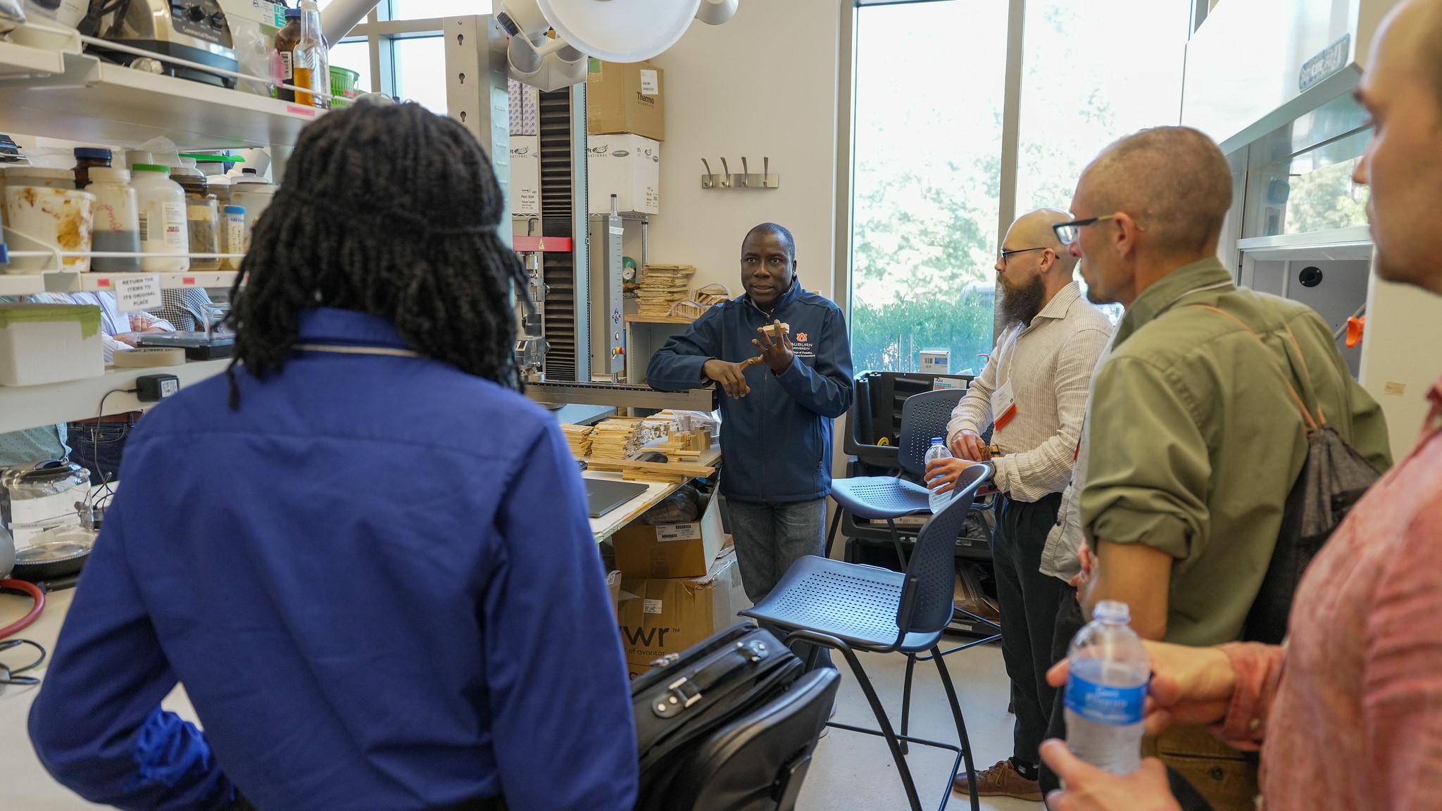 man speaking to a group in a lab 