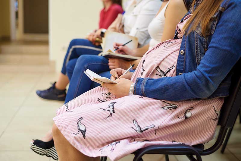 Several pregnant women sitting in chairs