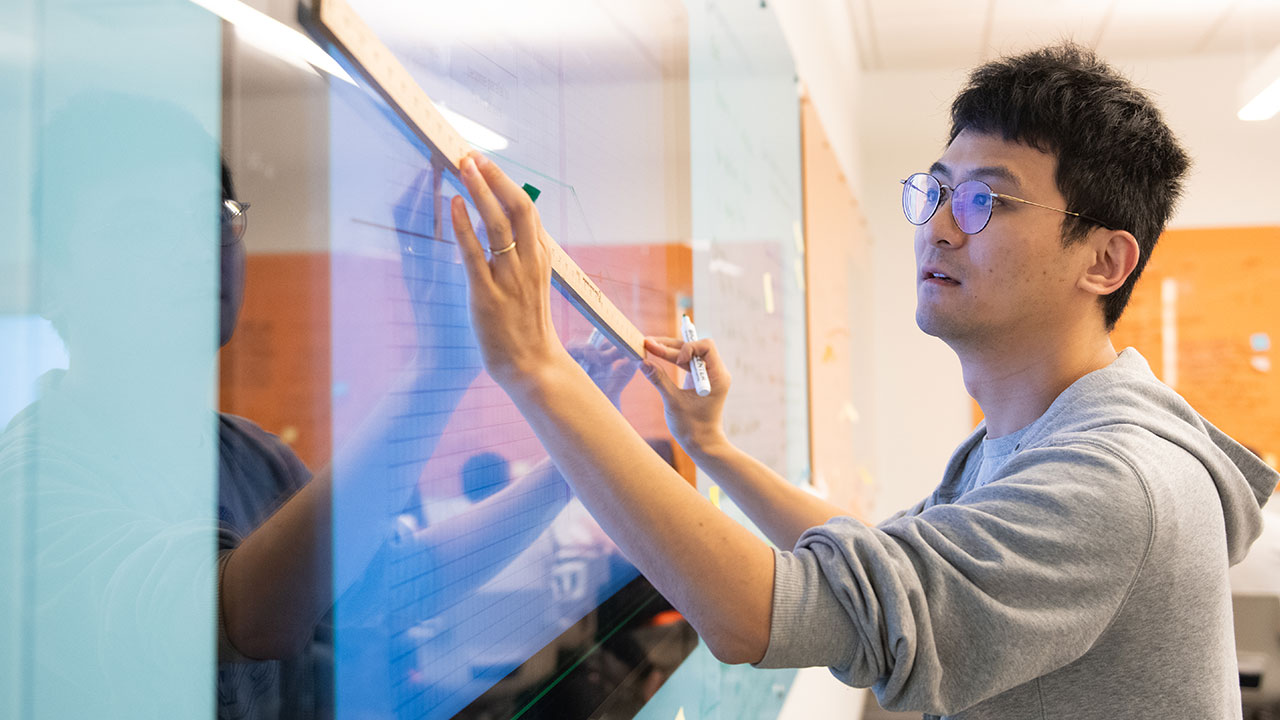 A student draws on a board