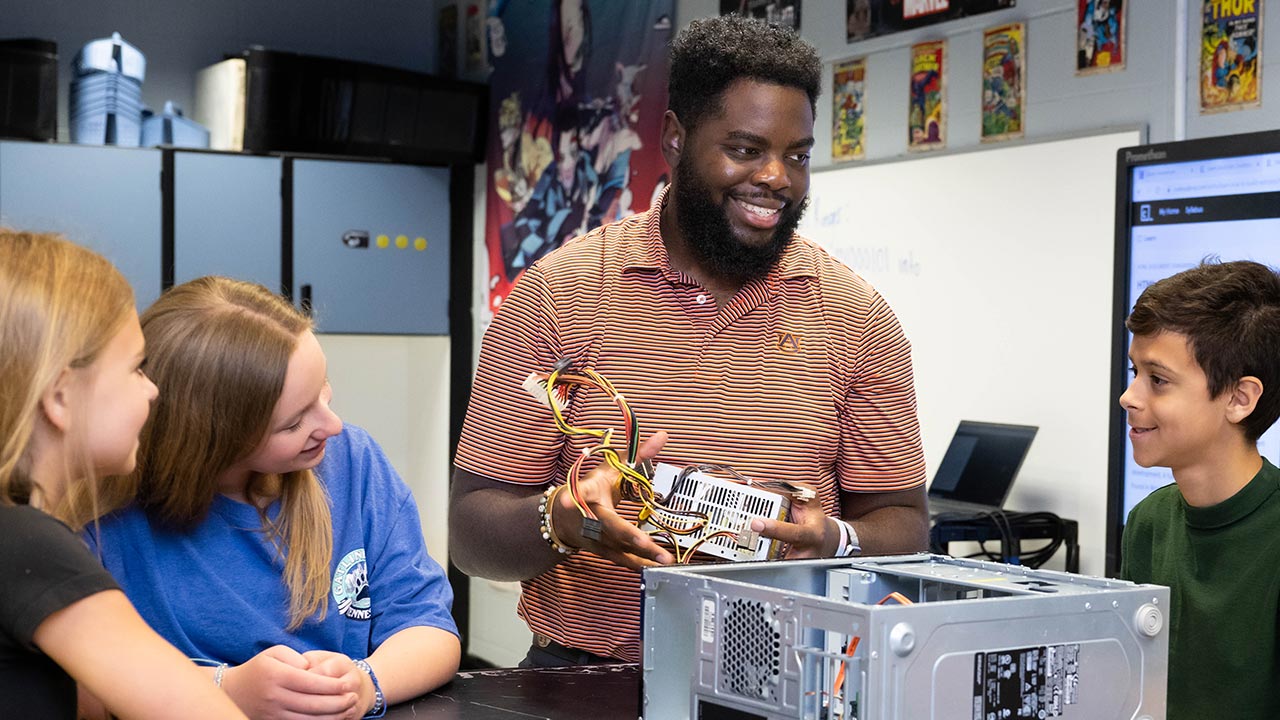 An instructor talks with young students
