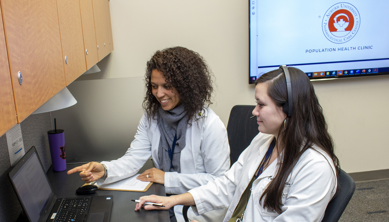 Preceptor and student discuss something on computer screen