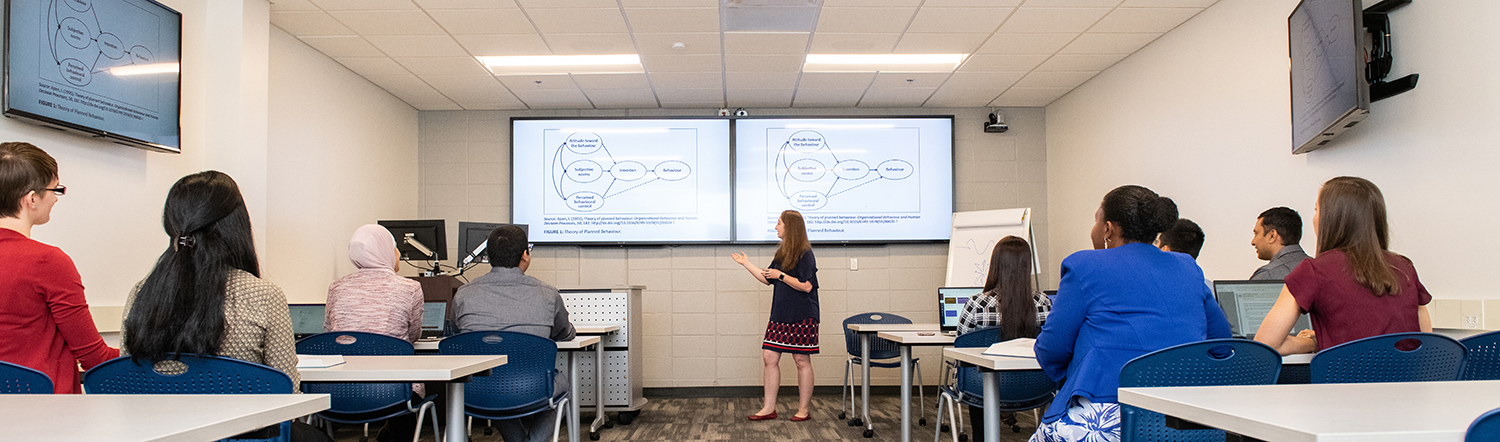 Professor stands in front of classroom