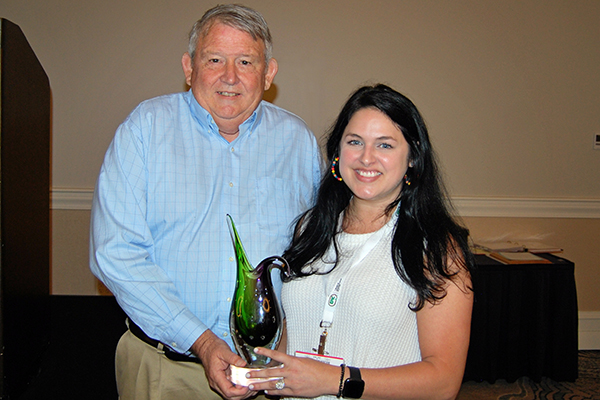 Danny Cottrell and Jessica Hung hold the award
