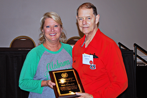 Louise Jones and Charlie Thomas hold the award