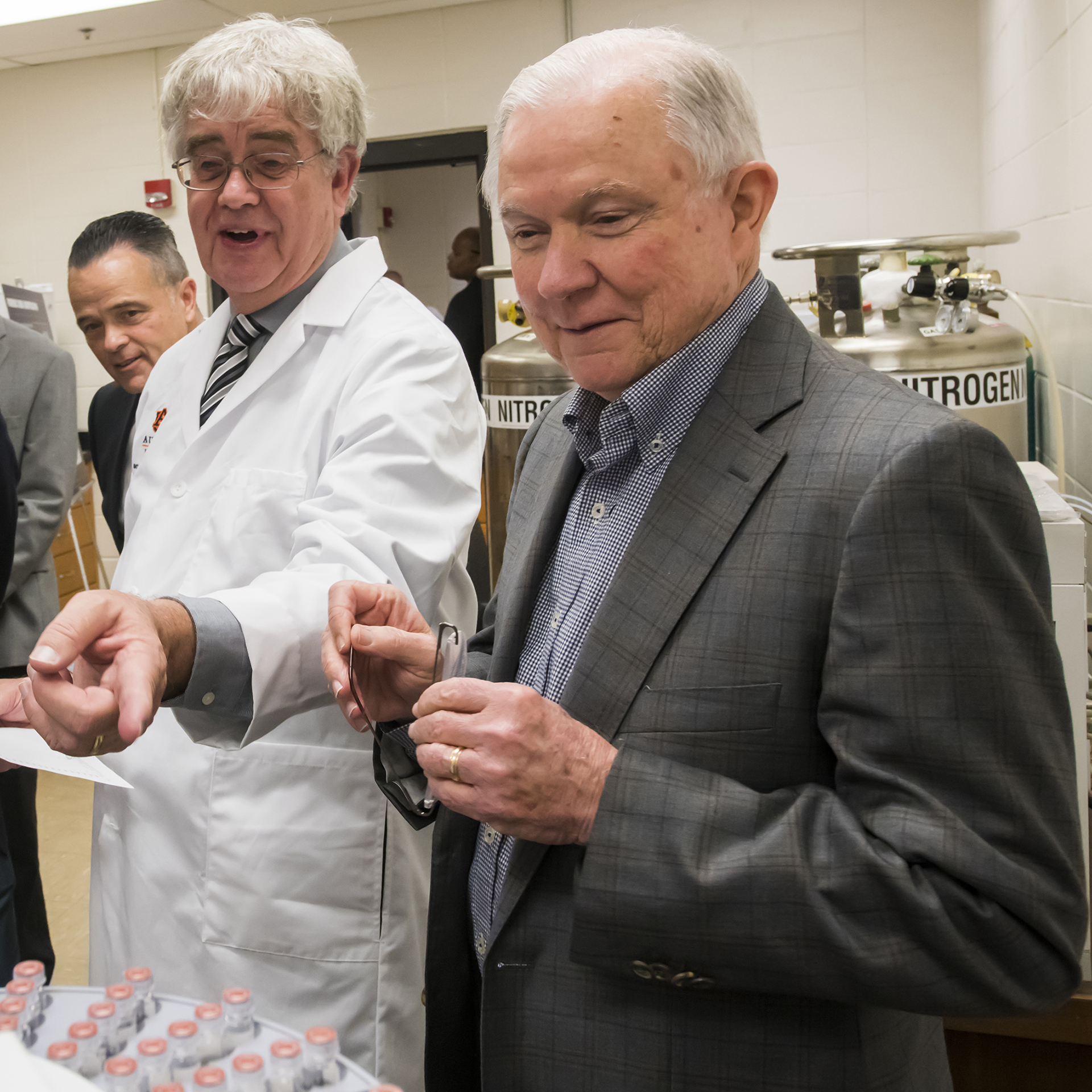 A group stands over a piece of scientific equipment