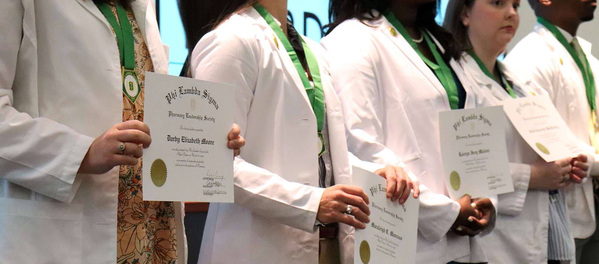 Students aligned holding certificates
