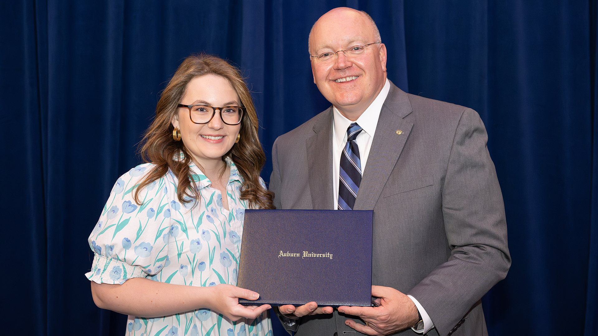 Two people stand together with certificate