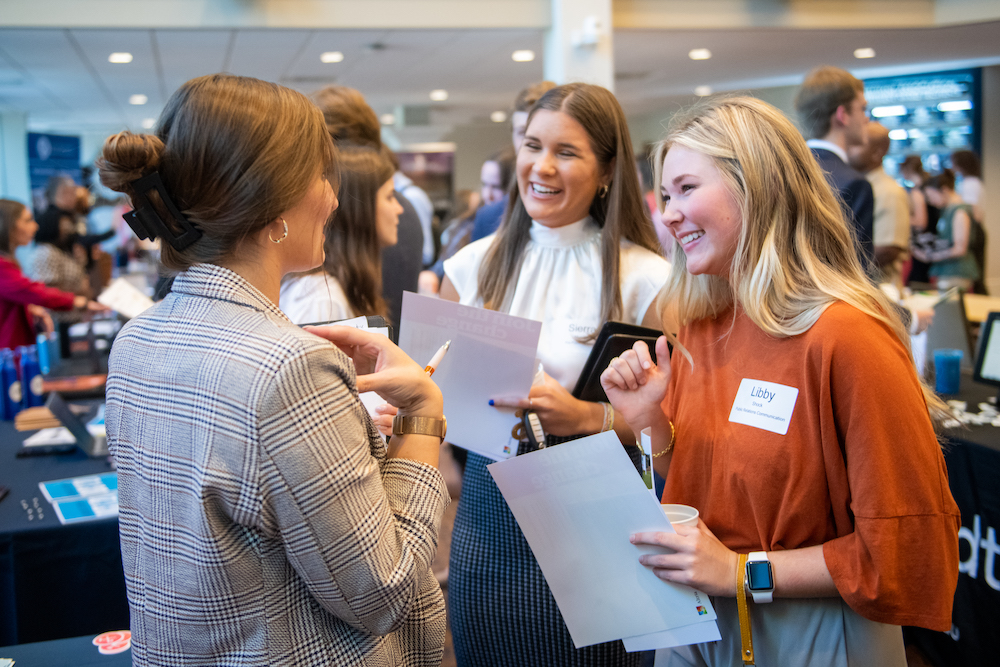 Two students talking with a PGA recruiter at the event