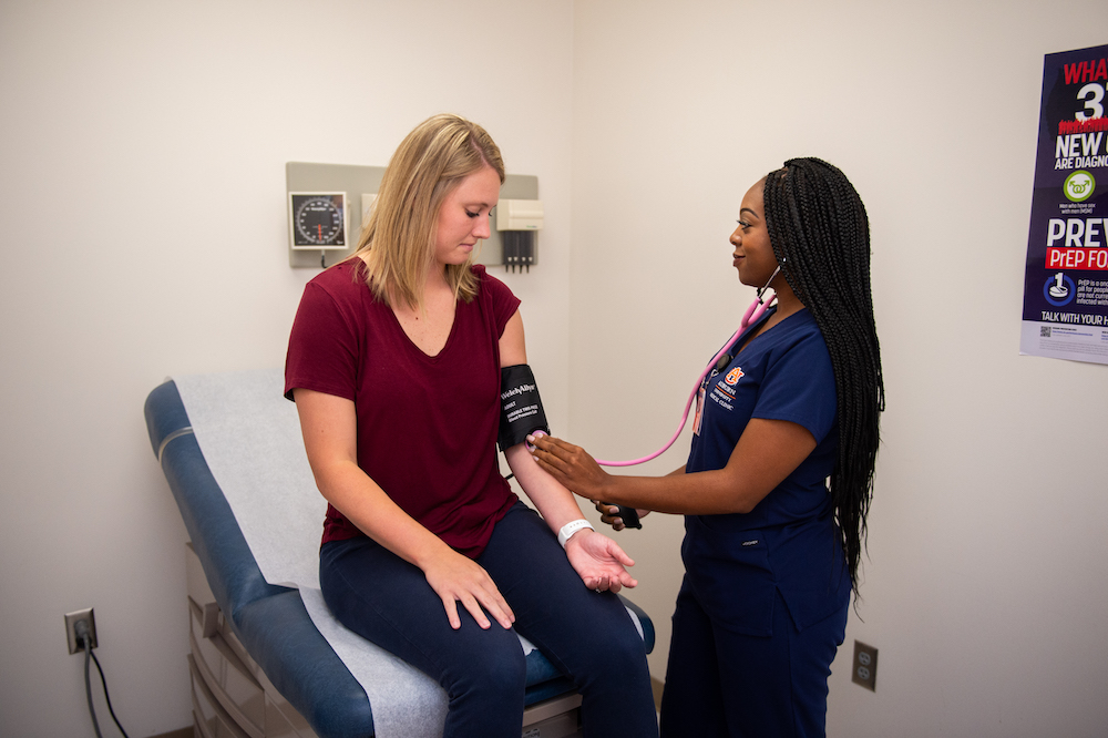 A medical professional taking a student's blood pressure at the clinic