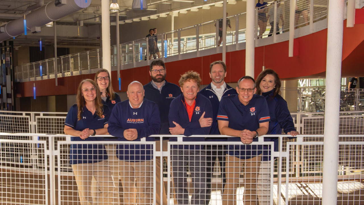 Campus Recreation and Wellness staff posing on the elevated walking track