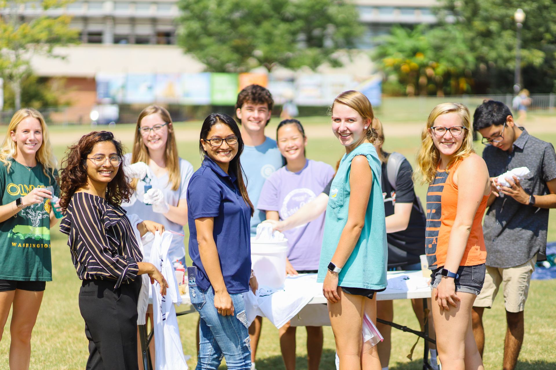 a group of students posing for a photo at an event on the campus green space